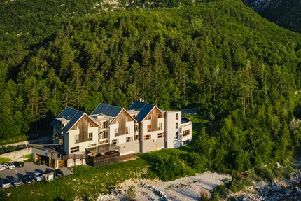 Hotel Boka © Hotel Boka Haus vor bewaldeten Bergen und Wasserfall im Tal