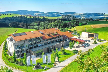 Landrefugium Obermüller © Stefan J. Wolf Photography Modernes Gebäude mit rotem Dach und Autos in grüner Hügellandschaft