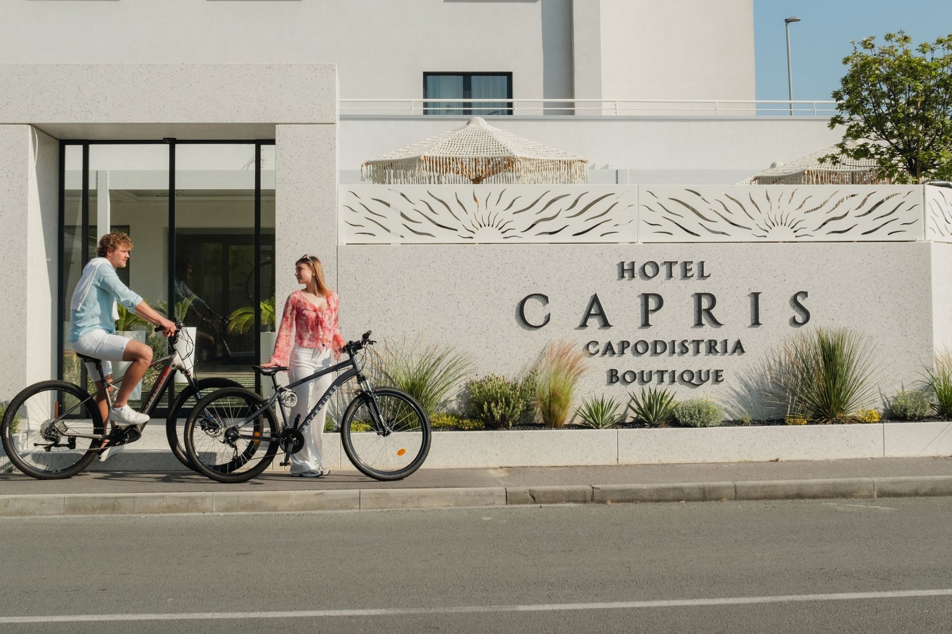 Roadbike Holidays © Hotel Capris Capodistria Boutique Mann und Frau mit Fahrrädern vor dem Hotel Capris