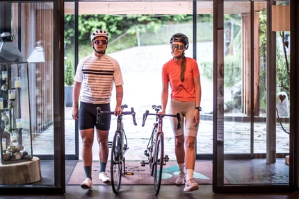 Sporthotel Zoll © Fabian Schaiter Zwei Radfahrer mit Helmen und Fahrrädern in einem modernen Gebäude