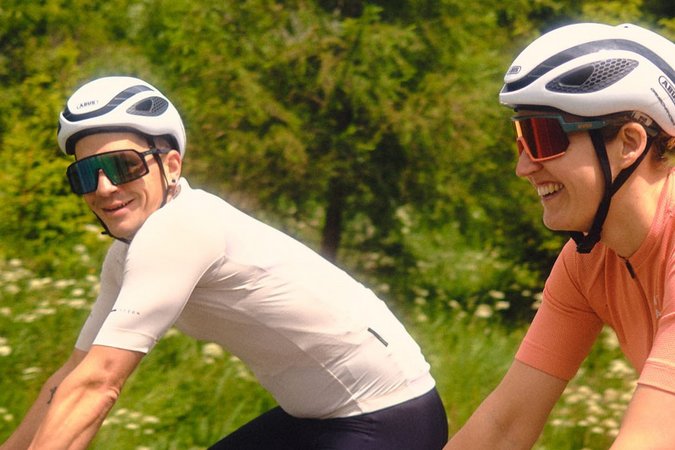 Roadbike Holidays © David Lemanski Zwei Radfahrer fahren auf einer Straße mit grüner Landschaft im Hintergrund