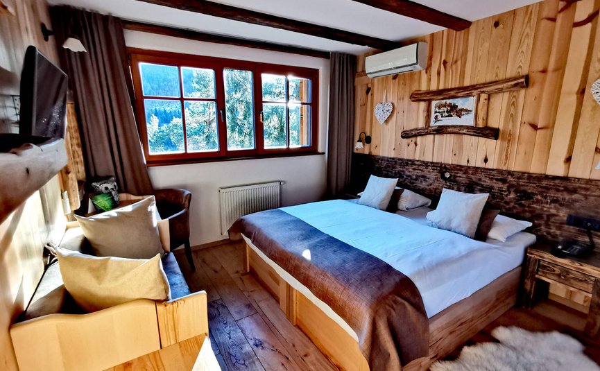 Hotel & Glamping Ribno Alpine Resort **** © Katarina Strgar Gemütliches Holzschlafzimmer mit Doppelbett und Bergblick aus dem Fenster