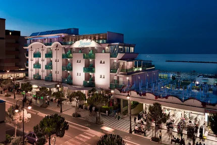 Lungomare Bike Hotel © Mario Flores Beleuchtetes Hotel am Meer mit Geschäften und Promenade bei Nacht