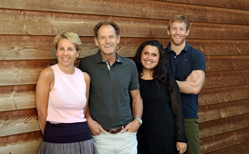 Sporthotel Exclusive **** © Sporthotel Exclusive SAS Four smiling adults standing against a wooden wall