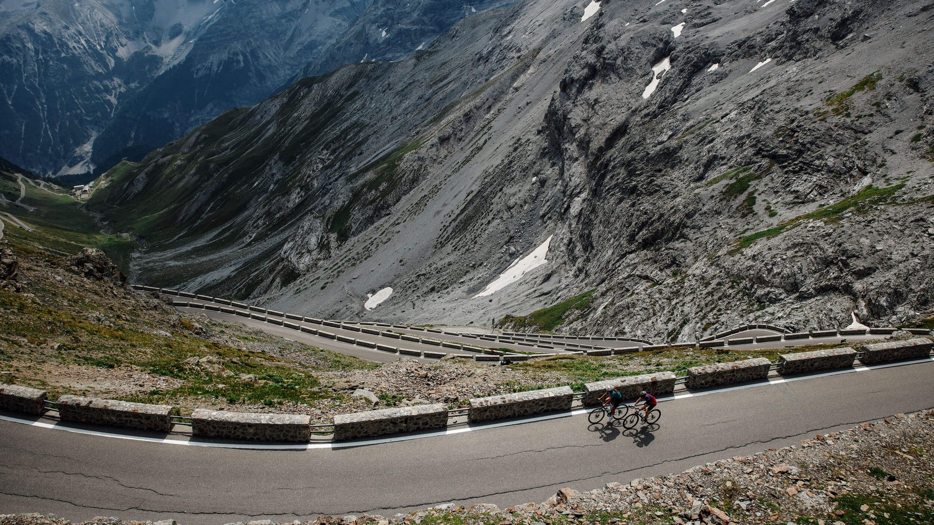 Roadbike Holidays © Felix Saller Zwei Radfahrer auf kurvenreicher Bergstraße mit steilen Felsen