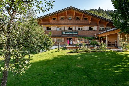 Gämsle Hotel, Wirtshaus & mehr … © Raffael F. Lehner Traditionelles Gasthaus mit grüner Wiese und Obstbäumen im Vordergrund