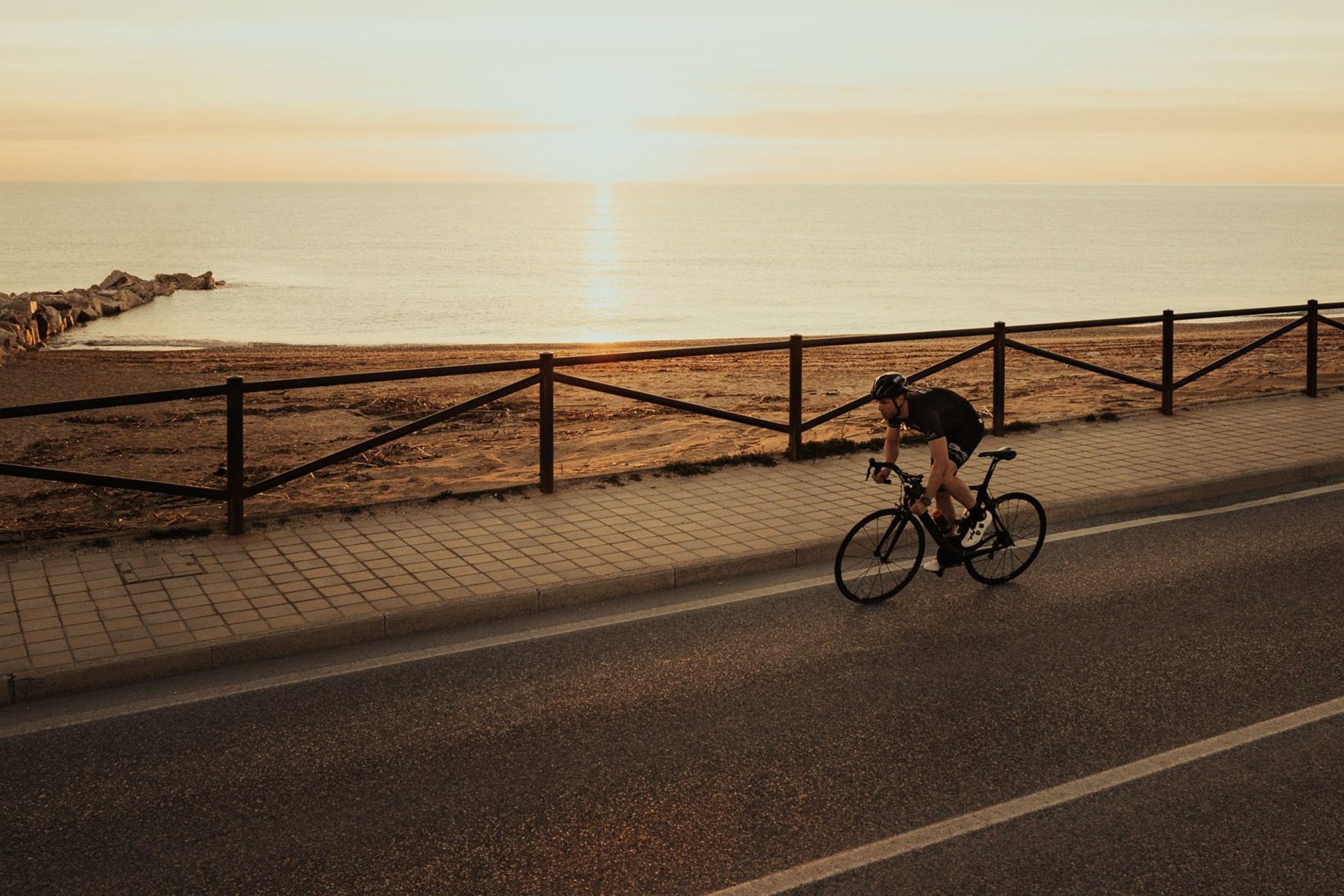 Roadbike Holidays © Alex Moling Radfahrer fährt am Meer entlang bei Sonnenuntergang
