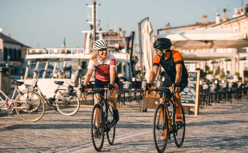 Road bike holidays on the Adriatic coast © Alex Moling Two cyclists, man and woman, riding on a paved path by the water