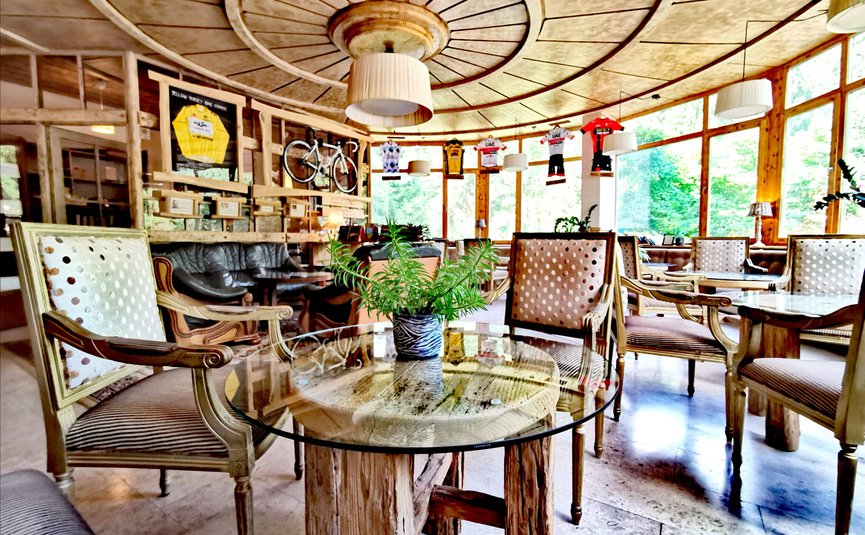 Hotel & Glamping Ribno Alpine Resort **** © Katarina Strgar Gemütlicher Gastraum mit Holzdecke, antiken Stühlen und Fahrraddekoration