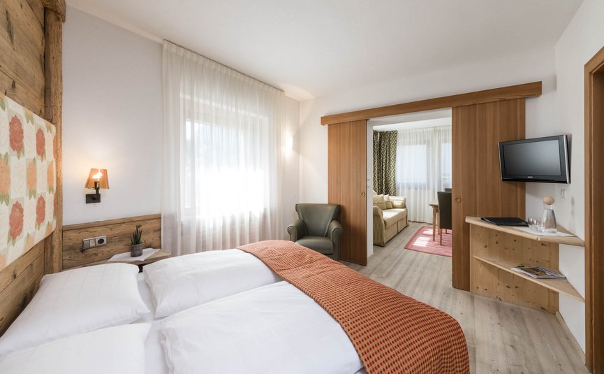 Sporthotel Exclusive **** © Hannes Niederkofler Bright hotel room with double bed and connected living area
