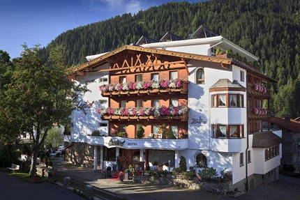 Alpen-Comfort-Hotel Central © Hotel Central Nauders Hotel mit Blumenschmuck an Balkonen in bergiger Landschaft