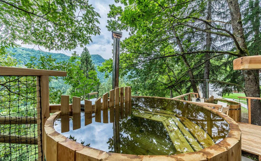 Hotel & Glamping Ribno Alpine Resort **** © Epidos doo Holzbadewanne mit Wasser auf einer Terrasse im Wald