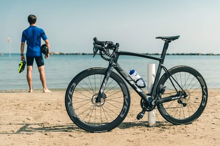 Saisonstart am Meer © Alex Moling Schwarzes Rennrad am Strand, Radfahrer blickt aufs Meer