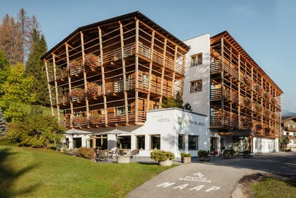 Hotel Melodia del Bosco © Alex Moling Hotel Melodia del Bosco mit Holzbalkonen und Blumen im sonnigen Bergumfeld