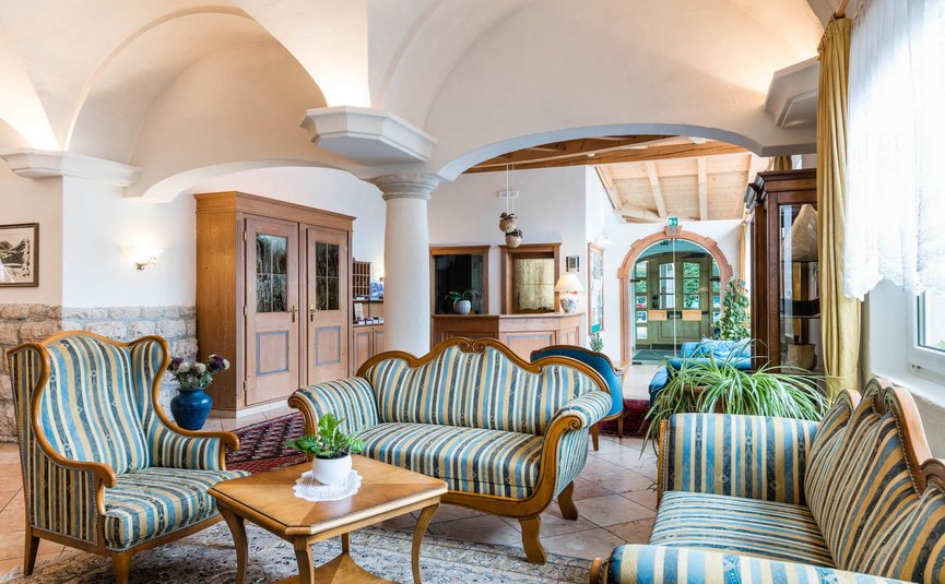 Sporthotel Exclusive **** © Sporthotel Exclusive SAS Bright hotel lobby with striped sofas and wooden furniture