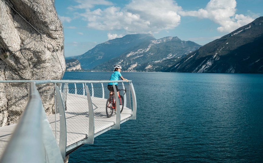 Racefietsvakantie aan het noordelijke Gardameer © Alex Moling Fietser op wandelpad met uitzicht op meer en bergen bij zonnig weer