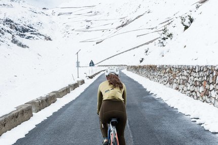Rennrad-Saisonausklang in Südtirol © Marc Mähler Radfahrerin auf bergiger Straße mit Schnee an den Seiten
