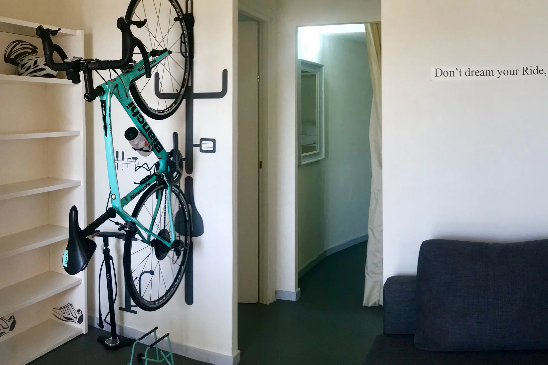 Roadbike Holidays © Villa Giada spEace & Bike Resort Fahrrad hängt an Wandhalterung in modernem Raum mit Zitat an der Wand