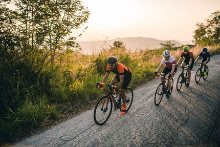 Nove Colli 200 © Alex Moling Four cyclists riding on a rural road uphill during sunset