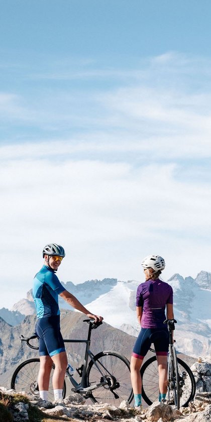 Roadbike Holidays © Josef Plaickner Zwei Radfahrer stehen mit ihren Fahrrädern in den Bergen bei klarem Wetter