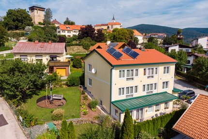 Bed&Breakfast Mittelkärnten © Bed and Breakfast Mittelkärnten Haus mit Solarpaneelen in einem Dorf mit Schloss im Hintergrund