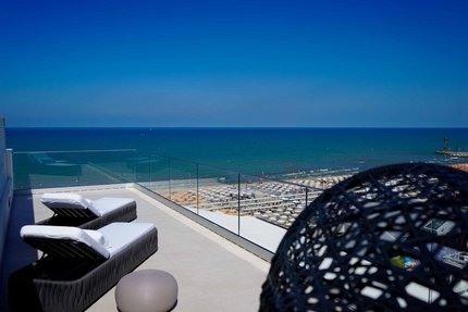 Hotel Arizona © Radio Bakery Riccione Zwei Liegestühle mit Meerblick und Strand unter blauem Himmel