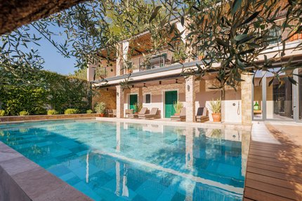 Hotel Vila Robida © Jaka Ivancic Moderner Pool mit Liegestühlen und grünen Türen an Haus